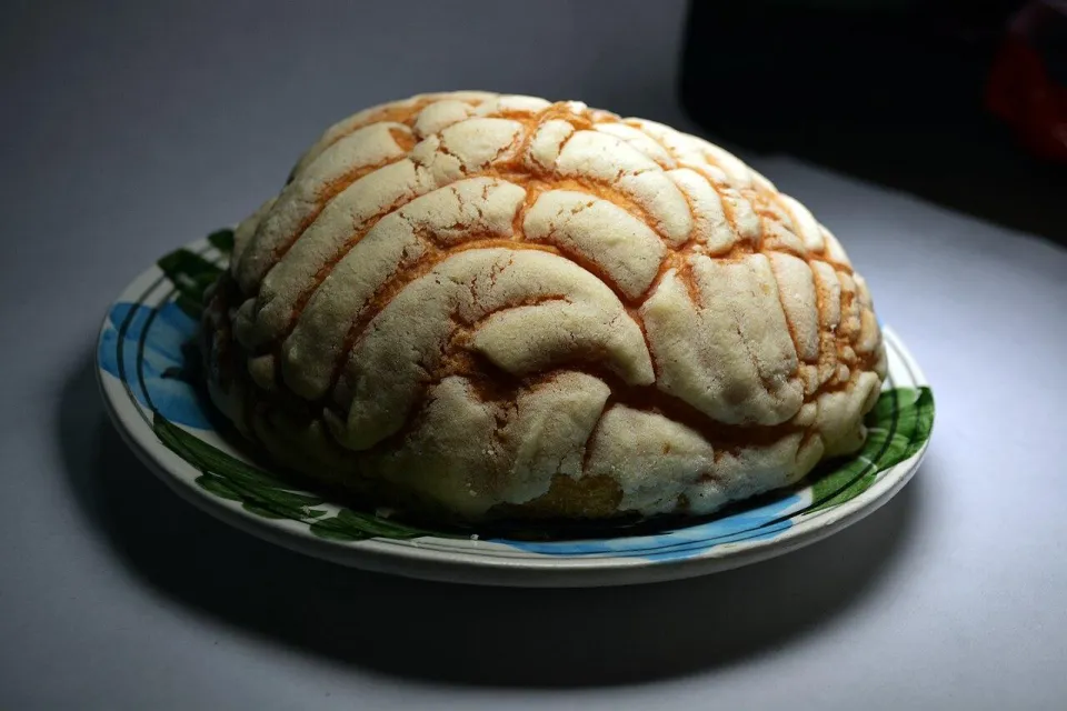 Мексиканская булочка конча с узорчатой сахарной корочкой на тарелке