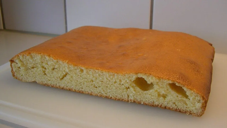 Разрезанный манник с румяной корочкой на белой доске