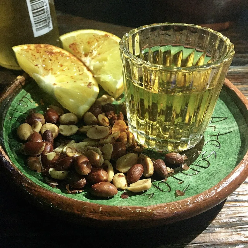Рюмка мескаля с дольками апельсина и жареным арахисом