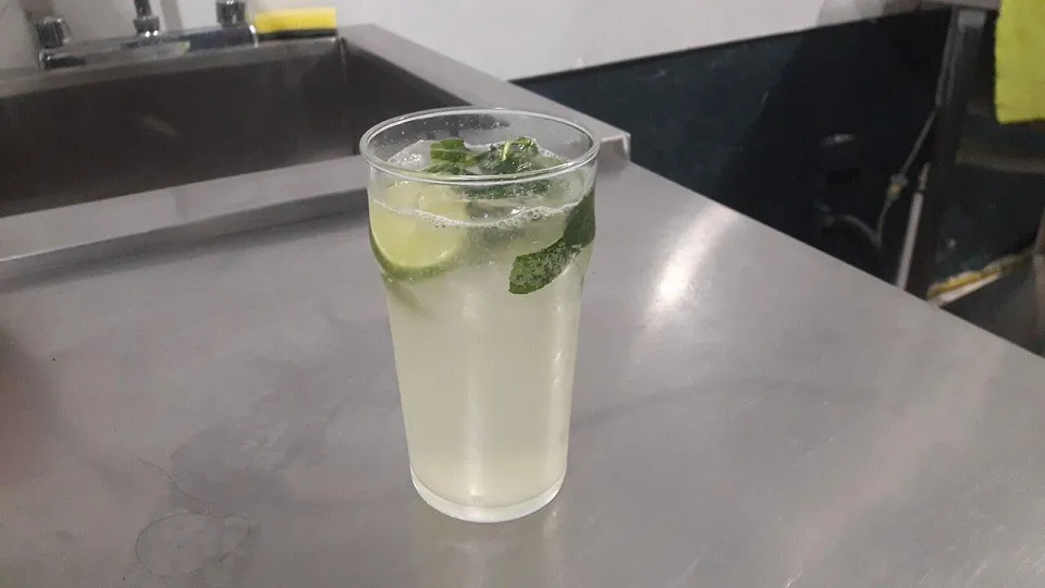 Коктейль мохито с мятой и лаймом в высоком стакане