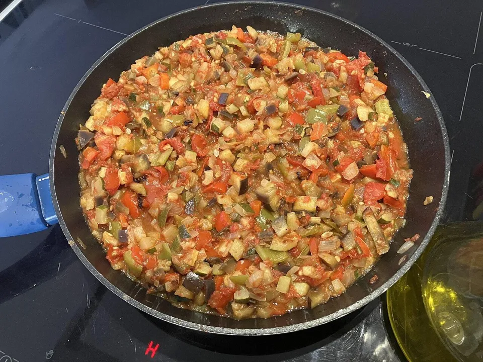 Тушёные кубики кабачков, перца, баклажана и томатов в сковороде