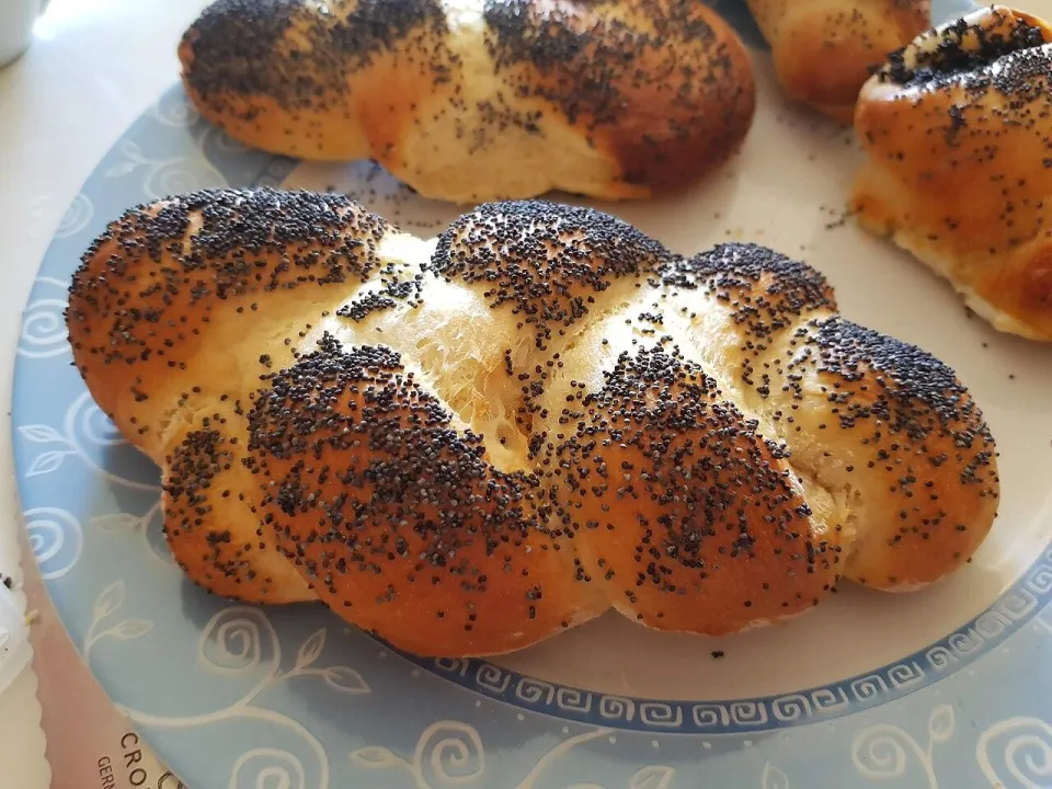 Скрученная булочка с маком на тарелке