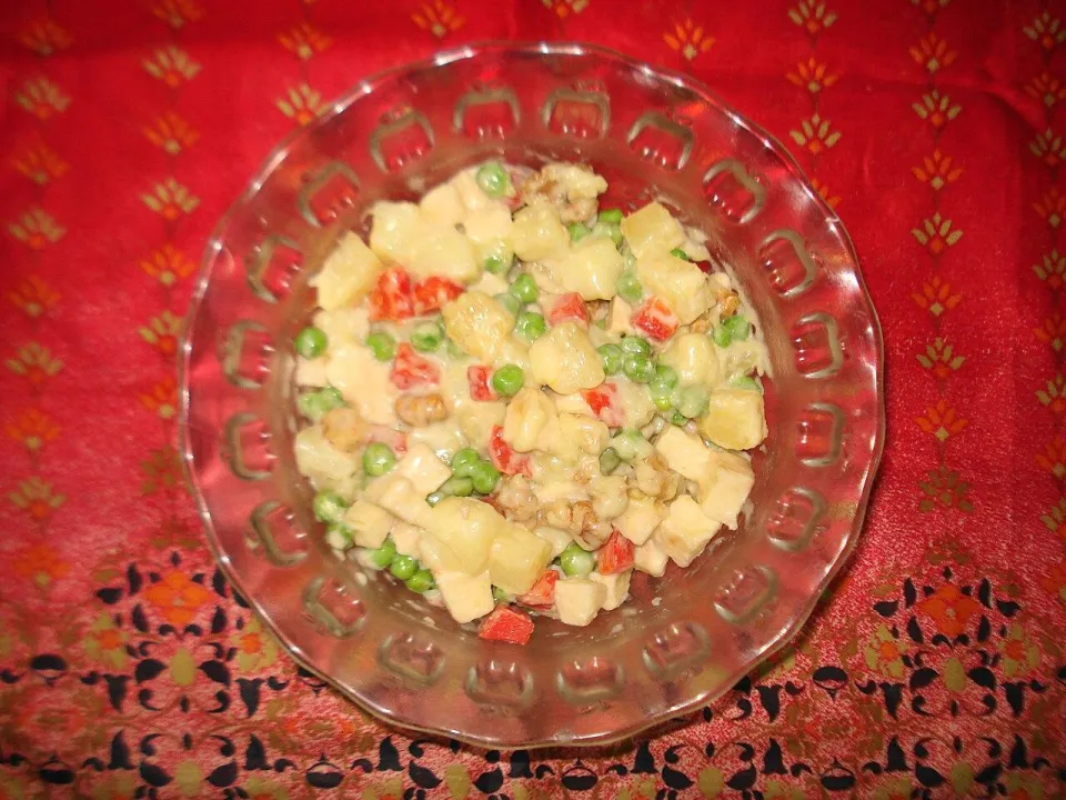 Салат из кубиков картофеля, моркови, зелёного горошка и перца в стеклянной тарелке