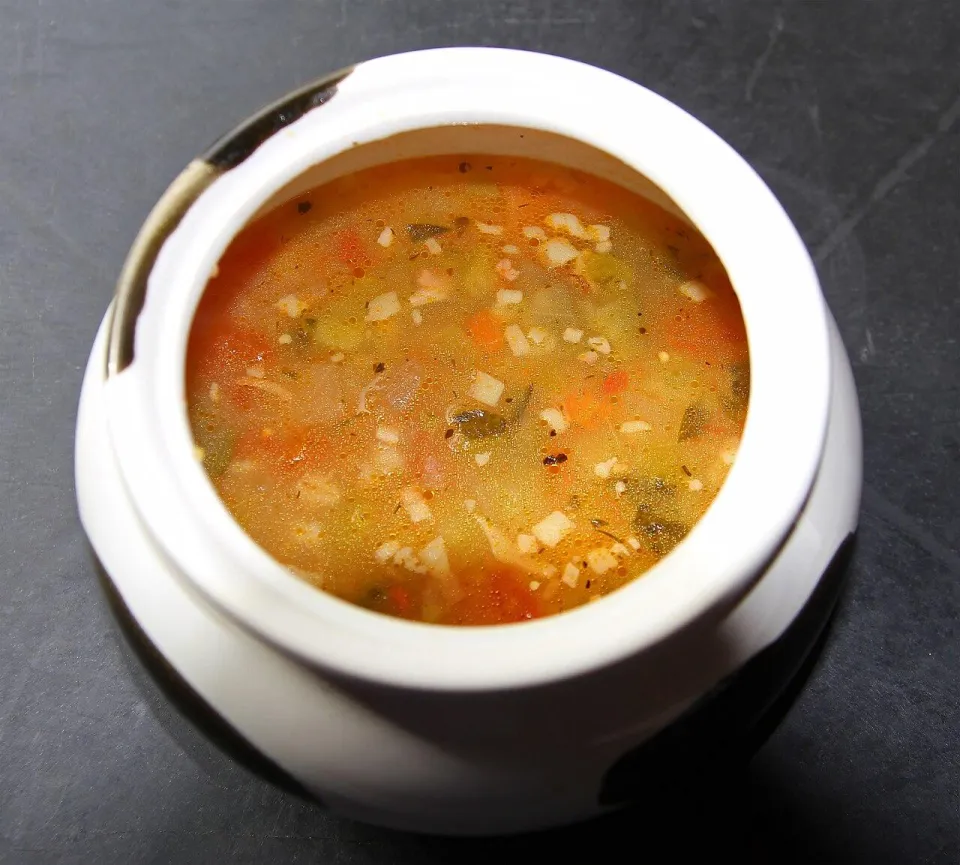 Тарелка рассольника с перловкой, морковью и огурцами в белом горшочке