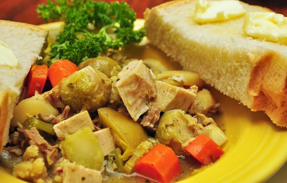 Суп из индейки с брюссельской капустой, морковью и картофелем в жёлтой тарелке