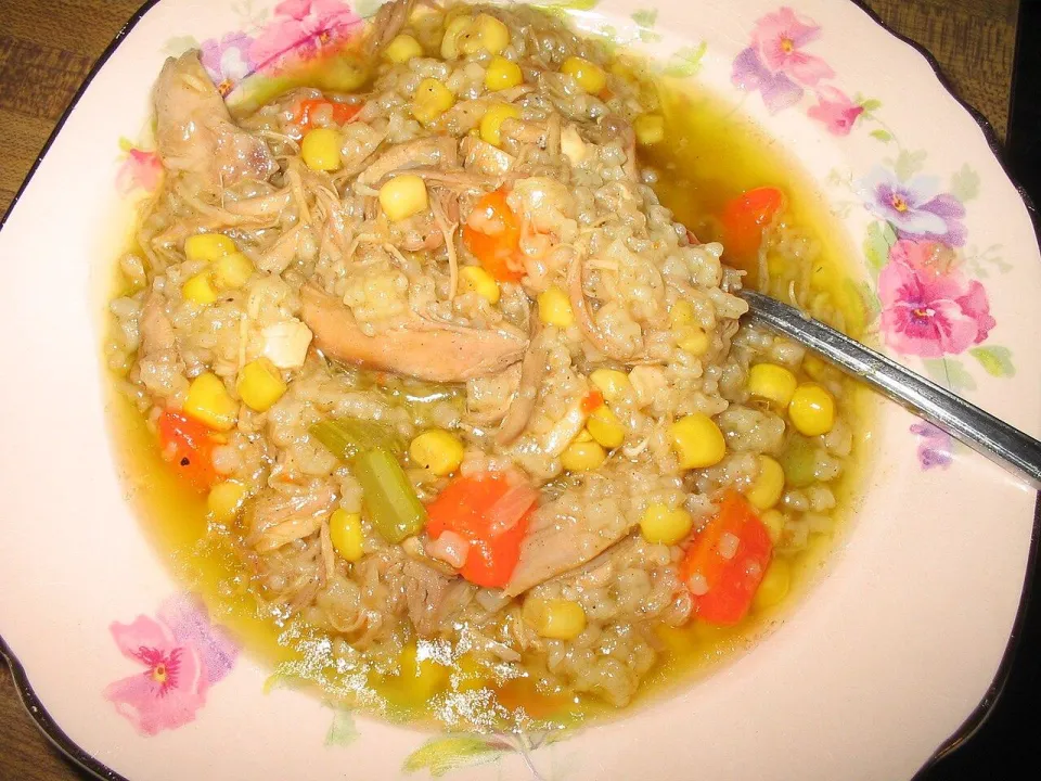 Суп из индейки с рисом, кукурузой и морковью в тарелке