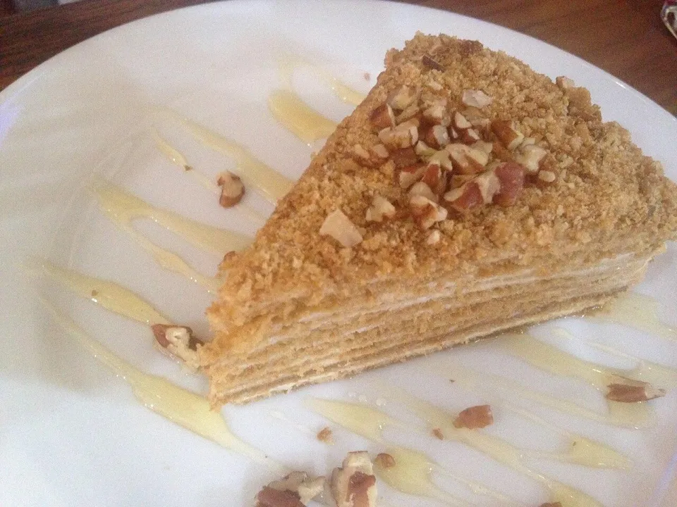 Кусок медовика с тонкими коржами, крошкой и орехами